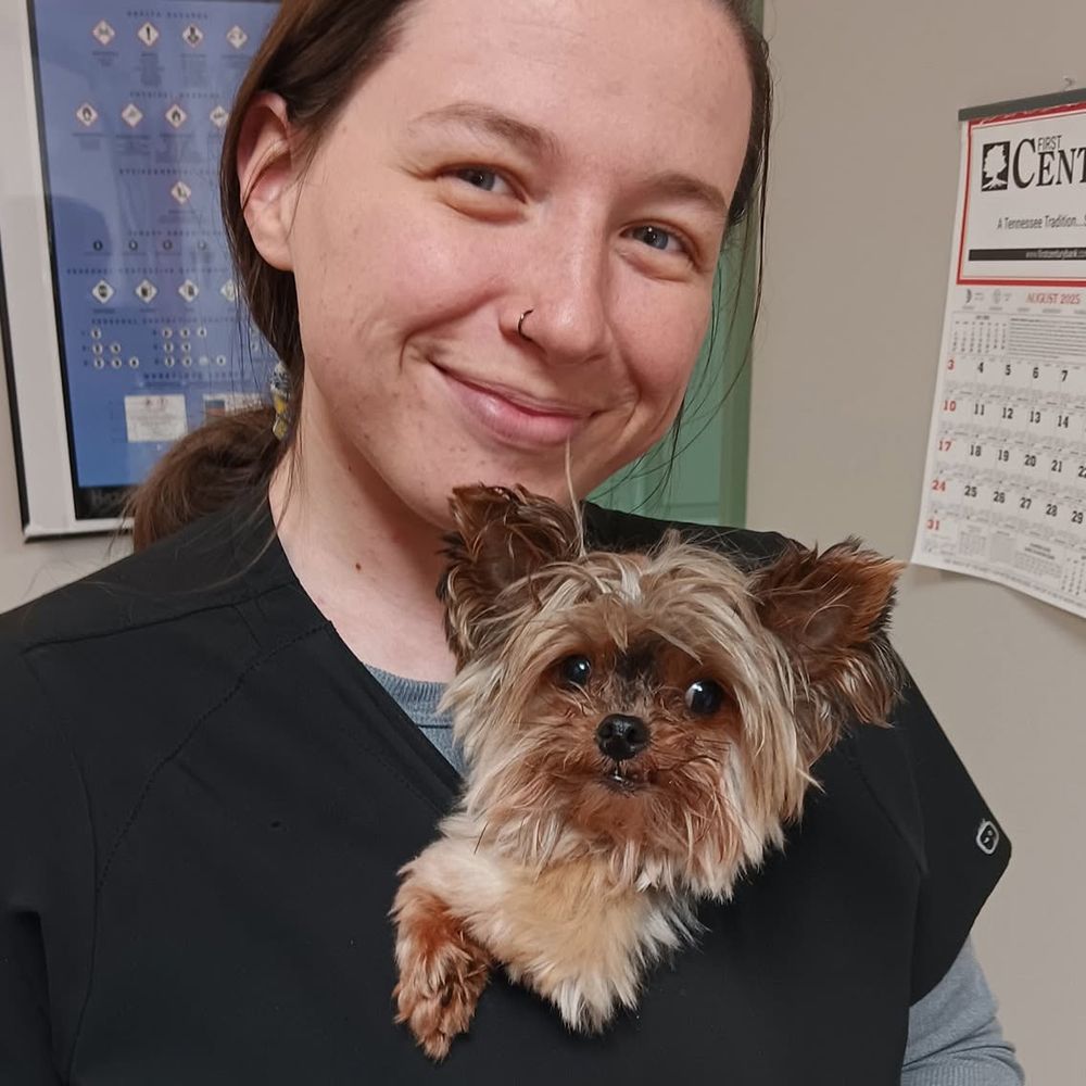 smiling woman holding small dog